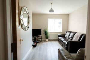 a living room with a leather couch and a mirror at New Street Corner in Dungiven