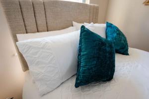 un letto con cuscini bianchi e blu di New Street Corner a Dungiven
