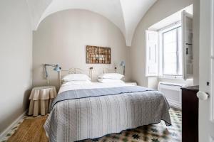 a white bedroom with a bed and a window at Casa Garcia in Amareleja