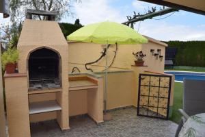 a play kitchen with an umbrella on a patio at Casa L'Escala 30 in L'Escala