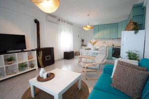 sala de estar con sofá azul y cocina en Sea Breeze Paradise en Palioúrion