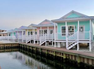 a row of houses on a dock next to the water at Key West Cottages in Chincoteague