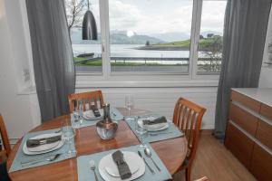 a dining room table with a view of the water at Hermitage Sihlsee in EGG