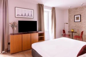 a bedroom with a bed and a flat screen tv at DownTown Boutique House in Rome