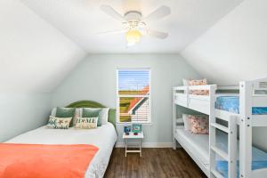 a bedroom with two bunk beds and a ceiling fan at Walk to Beach, Sunset Bay Views, Pet Friendly - Sea Me Relaxin in Surfside Beach