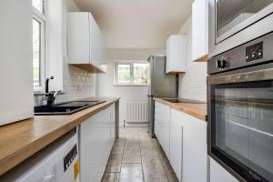 uma cozinha com armários brancos e um forno de aço inoxidável em Friendly Stockport em Stockport