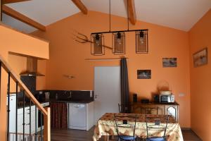 Cette chambre est dotée d'un mur orange avec une table. dans l'établissement Gîte PMR Evasion Camarguaise, à Beauvoisin