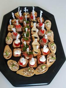 a black tray with a bunch of different types of food at Kriaunų bendruomenės Svečių namai in Gipenai