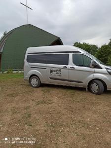 a van parked in front of a green building at Kriaunų bendruomenės Svečių namai in Gipenai