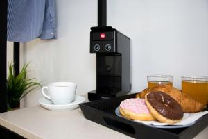 dos donuts en un plato en un mostrador con un café y bebidas en Big Max Guesthouse en Kávos