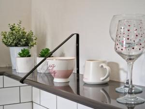 a glass table with cups and a wine glass at DYSA Abbey House in Blackpool