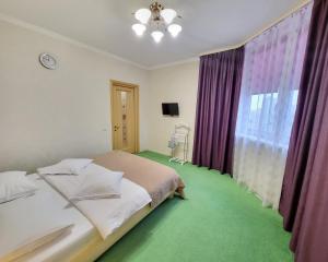 Schlafzimmer mit einem Bett und einem Fenster mit lila Vorhängen in der Unterkunft Kiev Apartment in Kiew