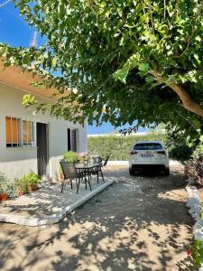 Agrabeli Cottage in Platanos في Plátanos: فناء مع طاولة وسيارة متوقفة بجوار منزل