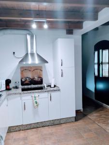 uma cozinha com armários brancos e um fogão em Azahar em Sevilha