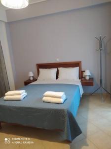 a bedroom with a blue bed with two towels on it at Agrabeli Cottage in Platanos in Plátanos