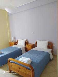 a bedroom with two beds with blue and white sheets at Agrabeli Cottage in Platanos in Plátanos