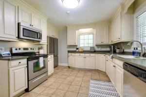 a kitchen with white cabinets and a sink at Fayetteville Vacation Rental - 1 Mi to Downtown! in Fayetteville