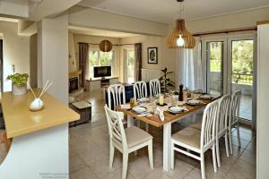 a dining room and living room with a table and chairs at Eleni's Pool Villa in Káto Soúlion