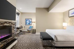 a hotel room with a bed and a flat screen tv at Magnolia Hotel Denver, a Tribute Portfolio Hotel in Denver
