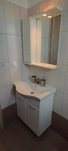y baño con lavabo blanco y espejo. en Bouvegio Apartments Giorgos en Afántou
