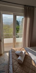 a bedroom with a bed and a large glass window at Bouvegio Apartments Giorgos in Afantou