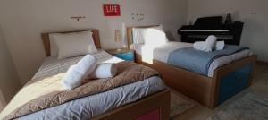 Habitación pequeña con 2 camas y piano en Bouvegio Apartments Giorgos en Afántou