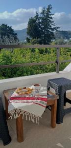 a table with a plate of food and a cup of coffee at Bouvegio Apartments Giorgos in Afantou