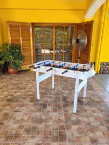 mesa de ping pong en una habitación con ventilador en Yellow House en Tunuyán