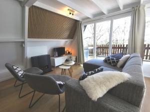a living room with a blue couch and chairs at Chalet Het Bosnestje Durbuy in Durbuy +35 photos