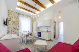 a kitchen and living room with a table and chairs at Luxury Rose Apartment in Dubrovnik