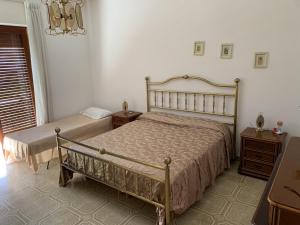 a bedroom with two beds and a chandelier at Appartamento Policastro Bussentino in Policastro Bussentino