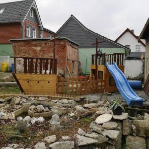 um quintal com um parque infantil com um escorrega em Günstige, schöne Ferienwohnung im Wanderparadies em Wernigerode