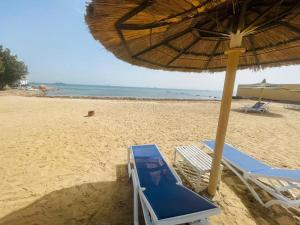 a beach with chairs and an umbrella on the sand at Navy Chalet 108 in Hurghada