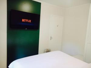 a bedroom with a bed and a tv on the wall at Pousada Morro do Elefante in Campos do Jordão