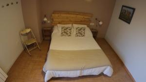 a bedroom with a bed and a chair in it at Castell de Ceuró. Hotel Rural in Ogern