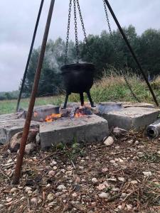 a pot on a swing over a camp fire at Oaza spokoju w lesie in Stara Kiszewa