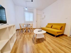 sala de estar con sofá amarillo y mesa en Exclusivo Apartamento en el Centro de Sevilla, en Sevilla
