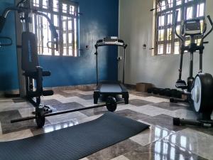 a gym with two exercise bikes and a treadmill at 3A'S COASTAL GUEST HOUSE in Riambel