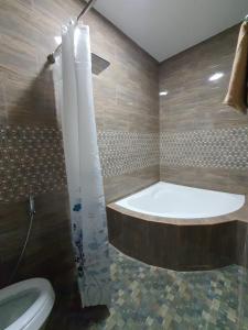 a bathroom with a bath tub and a toilet at 3A'S COASTAL GUEST HOUSE in Riambel