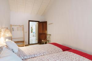 a white bedroom with two beds and a mirror at Casa Morera - Best Villas Lanzarote in Teguise