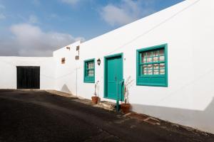 a white building with green windows and a door at Casa Morera - Best Villas Lanzarote in Teguise
