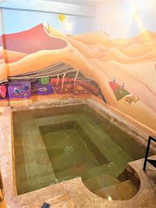 a swimming pool with a mountain mural on the wall at Kasbah Titrit & Spa in Aït Benhaddou