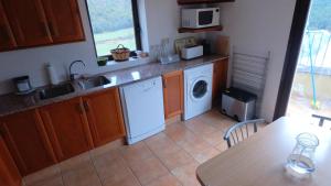 uma cozinha com um lavatório e uma máquina de lavar roupa em Castell de Ceuró. Hotel Rural em Ogern