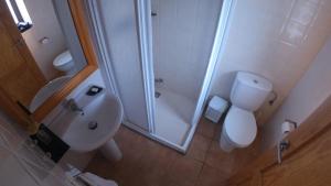 Un baño con ducha, inodoro y lavabo. en Castell de Ceuró. Hotel Rural, en 