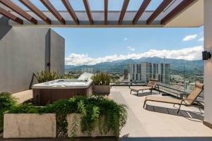 - un balcon avec un bain à remous et des chaises dans un bâtiment dans l'établissement Rooftop Jacuzzi and city view, à San José