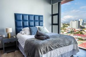 um quarto com uma cama grande e uma janela grande em Rooftop Jacuzzi and city view em San José