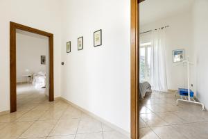 a hallway with a white wall and a mirror at La casa di Ele 2-100 metri dalla Reggia in Caserta