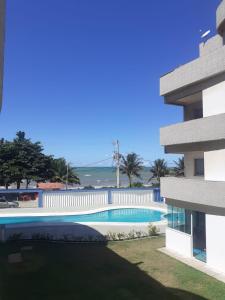 a view of a swimming pool next to a building at Apartamento 204 vista para o mar e piscina in Piúma