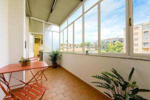 a balcony with a table and chairs and windows at La casa di Ele 2-100 metri dalla Reggia in Caserta