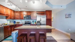 a large kitchen with wooden cabinets and a counter top at The Turtle Nest at Laketown Wharf #414 by Nautical Properties in Panama City Beach